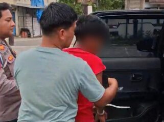 BL (baju merah) terduga pelaku cabul kepada kedua adik kandungnya sendiri saat diamankan polisi. Foto: Istimewa/Vressnews