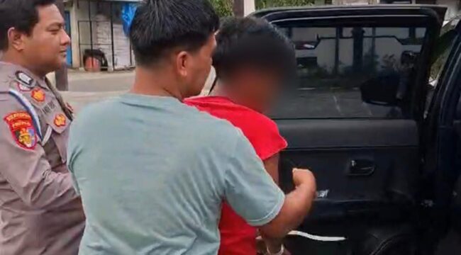 BL (baju merah) terduga pelaku cabul kepada kedua adik kandungnya sendiri saat diamankan polisi. Foto: Istimewa/Vressnews