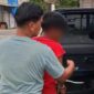 BL (baju merah) terduga pelaku cabul kepada kedua adik kandungnya sendiri saat diamankan polisi. Foto: Istimewa/Vressnews